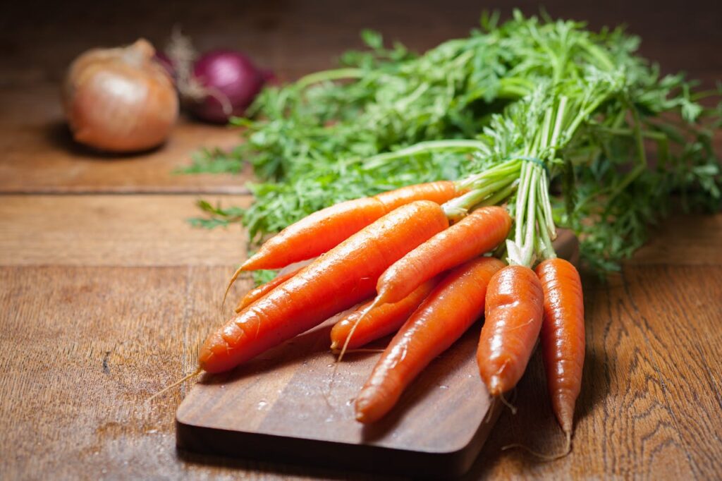 Carote fresche su un tagliere, una delle verdure più sicure e digeribili per i cani.