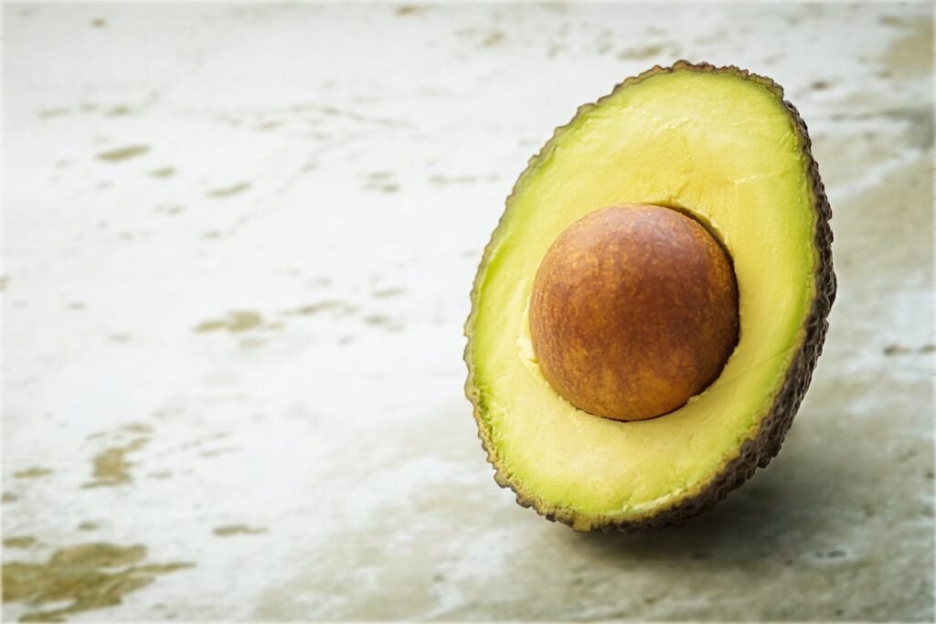 Mezzo avocado tagliato, alimento non adatto ai cani a causa della persina.