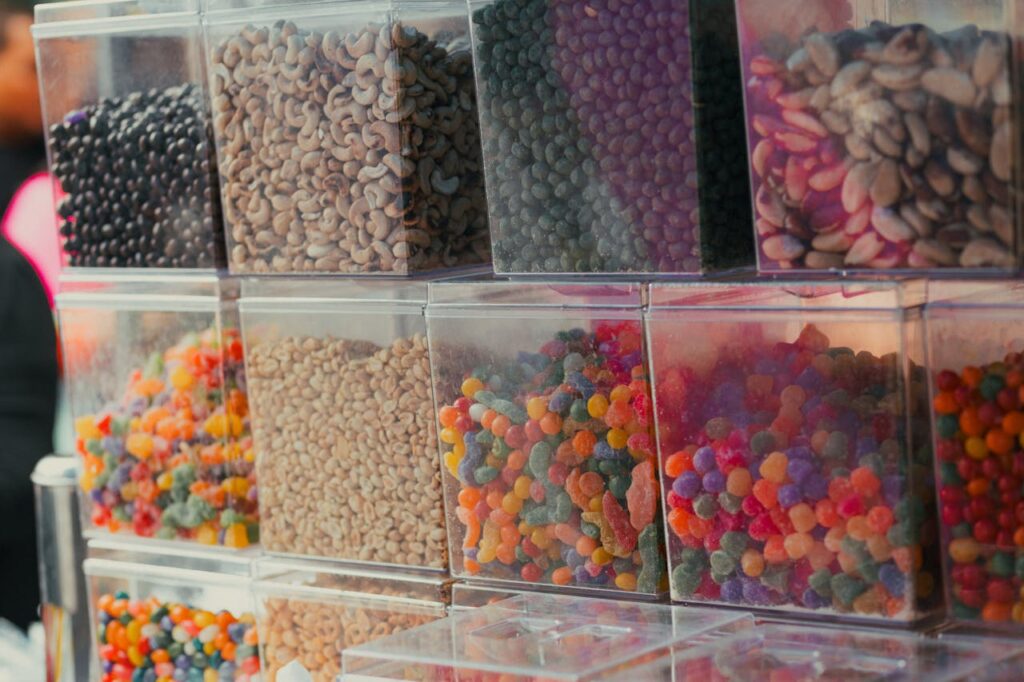 Scatole trasparenti piene di caramelle, simbolo dei prodotti che possono contenere xilitolo pericoloso per i cani.